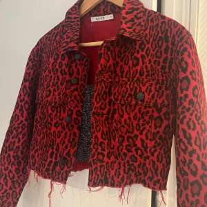 Jeansjacka i röd leoprint - Säljer min fina röda leoprint jeansjacka som är kortare i modellen och passar snyggt till fest 
