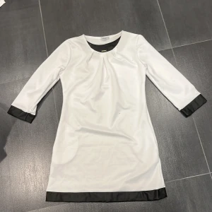 Vit klänning med svarta skin delar  - Använd 0-5 gånger.  liten i storleken 