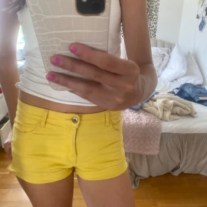 Gula jeansshorts - Säljer ett par snygga gula jeansshorts. De är lågmidjade och har en knapp och dragkedja framtill. Shortsen har fickor både fram och bak och är perfekta för sommaren. De är i nyskick och passar perfekt för både vardag och fest. 💛