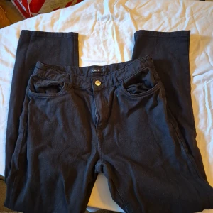 Svarta jeansbyxor från LMTD - Säljer ett par svarta jeansbyxor från LMTD i storlek S/M. Byxorna har en klassisk femficksdesign med knappar och dragkedja framtill. De är i bra skick och perfekta för både vardag och fest. Passar till allt och är superbekväma!