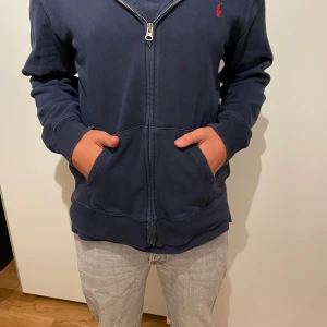 Ralph Lauren Hoddie - Säljer nu denna jättesnygga Ralph Lauren hoodien. Den är knappt använd och är i ett perfekt skick. 9/10 Storleken är 18-20 vilket motsvarar ca S. Modellen är 173 och väger ca 65