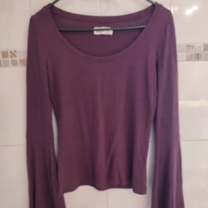Tröja  - Tröja med bell bottom på ärmarna, färg: vinröd/lila jättefin färg. I nyskick haft på mig den ca. 4-5 ggr. Material: 75% viskos, 21% polyester och 4% elestan