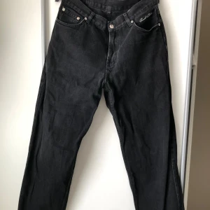 Svarta jeans från Sweetsktbs - Säljer ett par svarta jeans från Sweetsktbs i storlek S. De är tillverkade av 100% bomull och har en klassisk design med knappar och dragkedja. Perfekta för en avslappnad och stilren look. väldigt använda men i bra skick