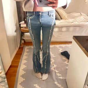 Blå bootcut jeans med fransdetaljer - Snygga blå bootcut jeans med unika fransdetaljer längs benen.  Väldigt unika!! Jag har sytt längs bootcuten men det går att sprätta upp om man vill. 