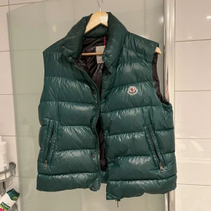 Grön dunväst från Moncler - Snygg grön dunväst från Moncler med dragkedja och två fickor framtill. Såklart äkta och är i storlek S, passar M också