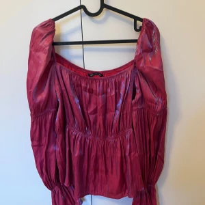 Rosa/glimmrig offshoulder topp från Shein - Snygg röd offshoulder topp från Shein med glittriga detaljer. Toppen har en smickrande passform och är perfekt för festliga tillfällen. Den är tillverkad i ett lätt och bekvämt material. Passar också som topp till Nyår. Storleken är Curve XXL, men jag skulle säga att den passar som en L.