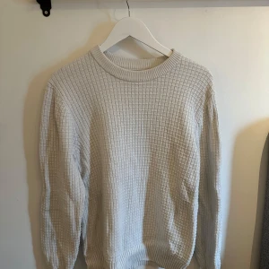 Vit stickad tröja från J.lindeberg - Säljer en stilren vit stickad tröja från J.Lindeberg. Tröjan har en ribbad struktur. Nypris 1500. Mycket bra skick. Pris 750