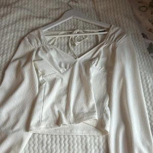 Vit långärmad topp från Gina Tricot - Säljer en stilren vit långärmad topp från Gina Tricot. Toppen har en liten öppen del i ryggen som gör den så snygg. Använd två gånger 