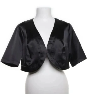 Svart bolero i satin -  svart bolero i satin med kortärmad design. Köpt på Plick och aldrig använt. 