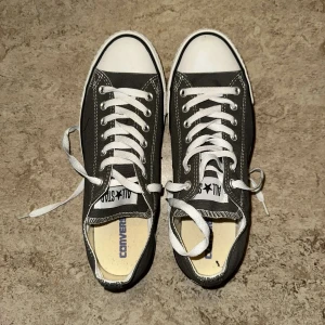  Converse All Star sneakers - Snygga grå Converse All Star sneakers med klassisk design. Skorna har vita snören och en vit tåhätta. Perfekta för en avslappnad stil.