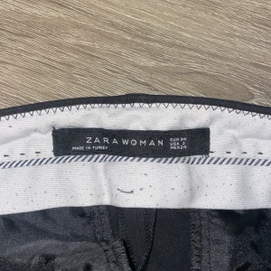 Svarta kostymbyxor från Zara Woman - Snygga svarta kostymbyxor från Zara Woman i storlek EUR 34. Byxorna har en klassisk rak passform och är perfekta för en stilren look. 