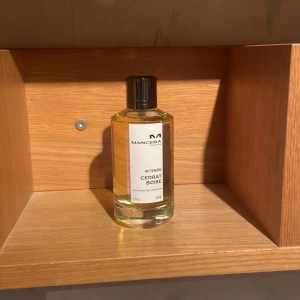 Mancera Intense Cedrat Boise Parfym - Exklusiv parfym från Mancera, Intense Cedrat Boise, i en elegant glasflaska med svart lock. Förpackningen är stilren och svart, vilket ger en lyxig känsla. Perfekt för den som söker en unik och intensiv doftupplevelse.