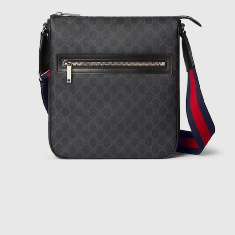Snygg svart axelväska från Gucci med klassiskt GG-mönster. Väskan har en justerbar axelrem i rött och blått samt en praktisk dragkedja framtill. Perfekt för att bära dina nödvändigheter med stil. Den är helt oanvänd. Vid fler frågor tveka inte att höra av er🤝🏼🤩. Laukut & Käsilaukut.