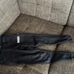 Svarta mjukisbyxor från Hoodrich - Säljer ett par svarta mjukisbyxor från Hoodrich i storlek XS. Byxorna har en avslappnad passform med resår i midjan och mudd vid bensluten. Perfekta för en bekväm och stilren look.