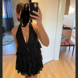 Svart glittrig klänning - Glitterchock klänning med öppen rygg helt ny prislapp kvar . Nypris 250kr 