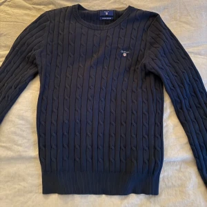 Gant kabelstickad tröja - Säljer en snygg mörkblå kabelstickad tröja från Gant i storlek S då den har blir lite för liten för mig