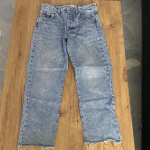 Blå jeans med rå kant - Snygga blå jeans med en rå kant vid bensluten. De har en klassisk femficksdesign och en bekväm passform. Perfekta för en avslappnad stil.
