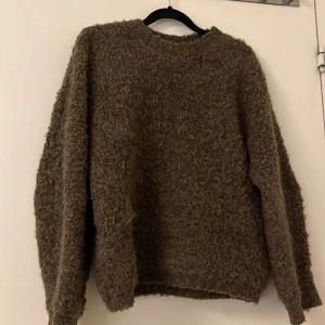 Brun fluffig tröja - Mysig brun tröja med fluffig textur. Perfekt för kyliga dagar med sin varma och bekväma design. Långärmad och enkel att matcha med olika outfits.