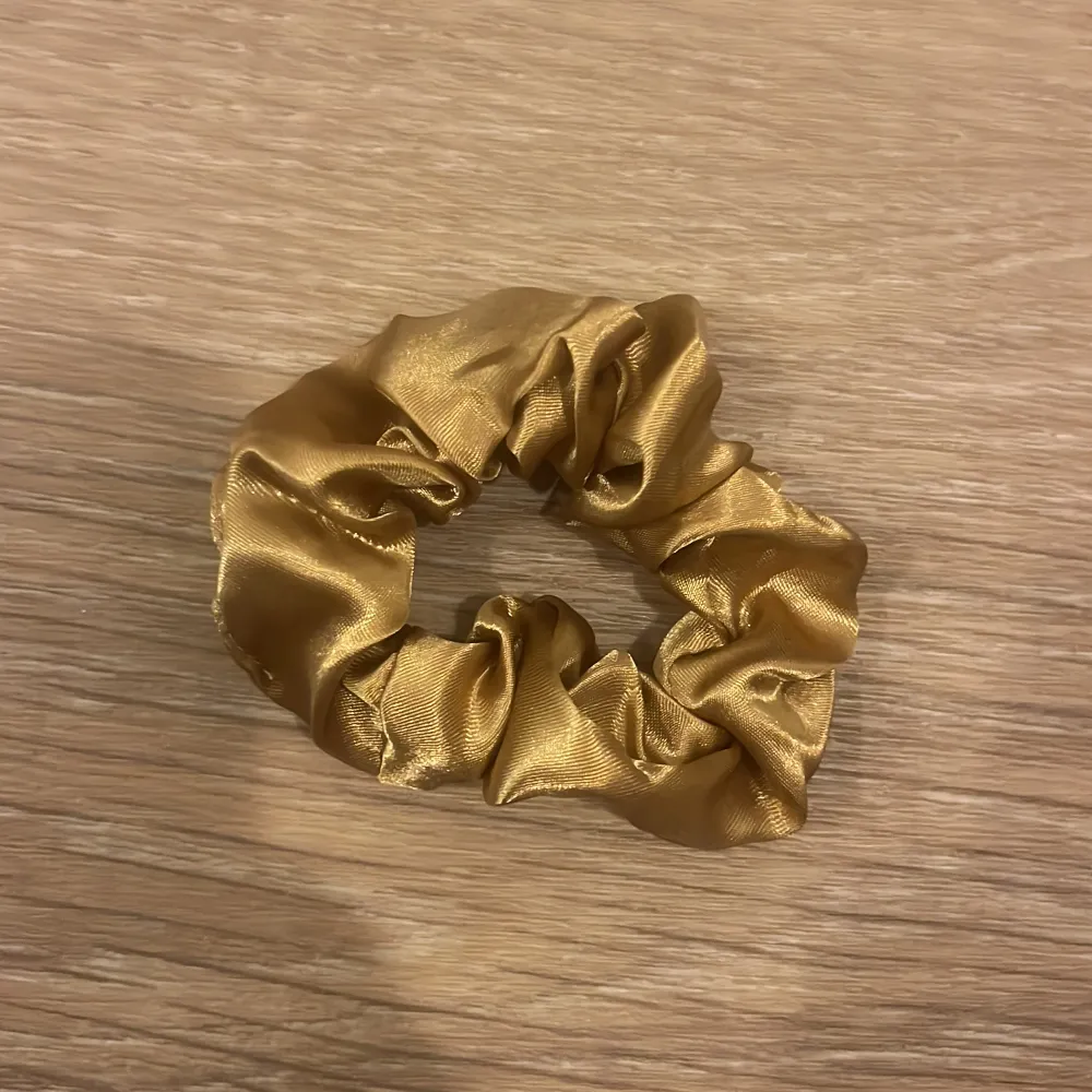 Snygg guld scrunchie i glansigt satinmaterial🩷. Asusteet.