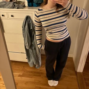 Randig ribbad tröja - Säljer en snygg randig tröja i ribbat material med blå och beige ränder. Tröjan har långa ärmar och en tight passform, perfekt för en stilren look.❤️