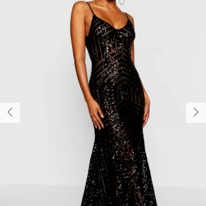 Svart glittrig långklänning - Säljer denna oanvända svarta långklänning med glittriga detaljer och smala axelband. Perfekt för festliga tillfällen som bal eller gala. Köpt på boohoo.