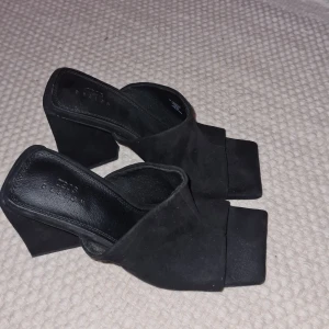 Klackskor med öppen tå, wide fit - Snygga svarta klackskor med öppen tå och fyrkantig form, wide fit. Fårn Asos. Skorna har en bred klack och är tillverkade i mocka imitation. Nypris 349kr