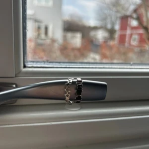 Silverfärgad ring med stjärndetaljer - En elegant silverfärgad ring dekorerad med små stjärnor runt om. Knappt använd. Passar bra till både vardag och speciella tillfällen. Sen en annan ring som har tappat en svart grej. Man kan köpa båda för 150kr eller en av dom för 90kr