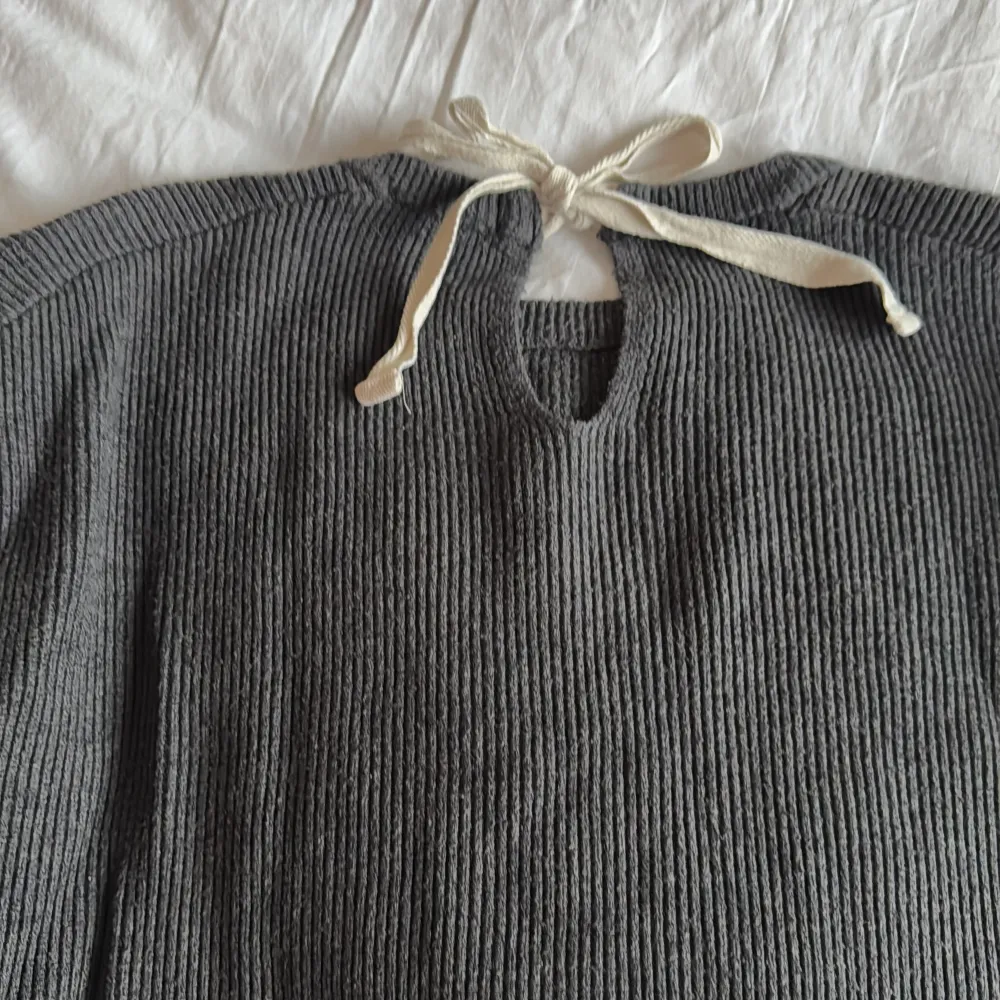 Mörkgrå stickad tröja från Zara. Den är ribbad och har en dekorativ knytning i nacken. Aningen nopprig men fortfarande fin, därav pris.. Neuletakit & Villapaidat.