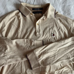 Beige croppad pikétröja  - Nude croppad pikétröja från Tommy Hilfiger med klassisk krage. Tryck i ryggen. Köpt från Brandy Melvilles vintage del. Passar s/m 