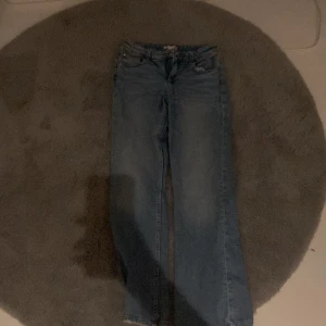 Blå jeans - Säljer ett par klassiska blå jeans med en straight passform. Perfekta för en avslappnad stil. De har en traditionell femficksdesign och knappgylf.