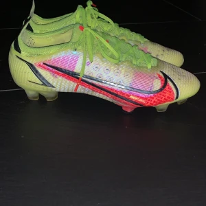 Nike mercurial fotbollsskor  - Snygga Nike fotbollsskor i neonfärger med en iögonfallande design. Skorna har en ljusgrön bas med röda och svarta detaljer samt snörning för optimal passform. Perfekta för fotbollsplanen! Skick 9/10 knappt använda. Storlek 41