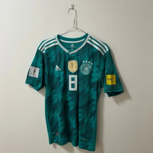 Tyskland fotbollströja ”Kroos” - Säljer en jättesnygg Tyskland fotbollströja med Kroos på ryggen. Färgen är väldigt unik, tröjan är från 2018. (Kvalificering till VM i Ryssland) där Kroos gjorde ett spektakulärt mål mot Sverige. 