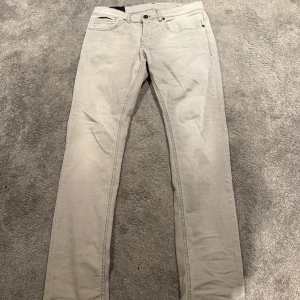 Grå jeansbyxor från Dondup - Snygga grå jeansbyxor från Dondup med en klassisk femficksdesign. Byxorna har en rak passform och är tillverkade i ett bekvämt bomullsmaterial. Perfekta för en stilren look.