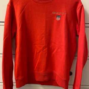 Röd tröja från GANT stl 176 - Fräsch röd tröja från GANT stl 176. Broderad logga på bröstet. Sparsamt använd, mycket fint skick.