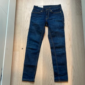 Mörkblå jeans från Dondup - Snygga mörkblå jeans från Dondup med klassisk femficksdesign och läderpatch med logga baktill. Jeansen har en slim passform och är tillverkade i ett stretchigt denimtyg för extra komfort.