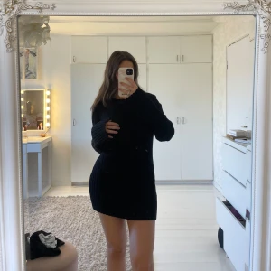 Svart ribbad klänning - Snygg svart ribbad klänning med lång ärm och en tight passform. Perfekt för en stilren look. Klänningen har en enkel design med rund hals och är tillverkad i ett stretchigt material.