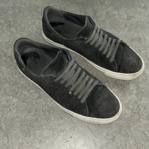 Gråa Axel arigato - Snygga gråa sneakers i mocka med vit sula och klassisk snörning. Perfekta för en stilren och grisch look.