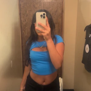 Blå croppad topp från Garage - Säljer en snygg blå croppad topp från Garage. Toppen har en unik cut-out detalj framtill och korta ärmar. Perfekt för en trendig look! Köpt för 350kr från USA men är tyväär inte min stil så har därmed bara använt 1-2 gånger. 