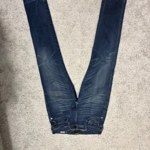 Mörkblå jeans från Replay - Snygga mörkblå jeans från Replay, modell Anbass. De har en klassisk femficksdesign och en bekväm passform. Perfekta för en stilren look.