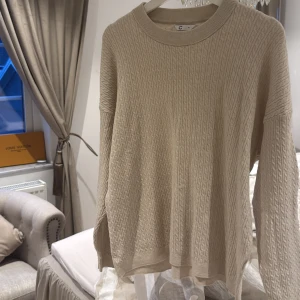 Beige stickad tröja från cubus - Säljer en stilren beige stickad tröja från märket Cubus. Tröjan har ett diskret kabelstickat mönster och långa ärmar. Perfekt för kyligare dagar. Passar bra till både jeans och kjol.