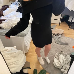Svart stickad klänning - Säljer en svart stickad klänning med offshoulder-design. Klänningen har långa ärmar och en tight passform som framhäver figuren. Perfekt för kyligare dagar när du vill vara både bekväm och stilren.  Skriv via intresse och fler bilder!✨
