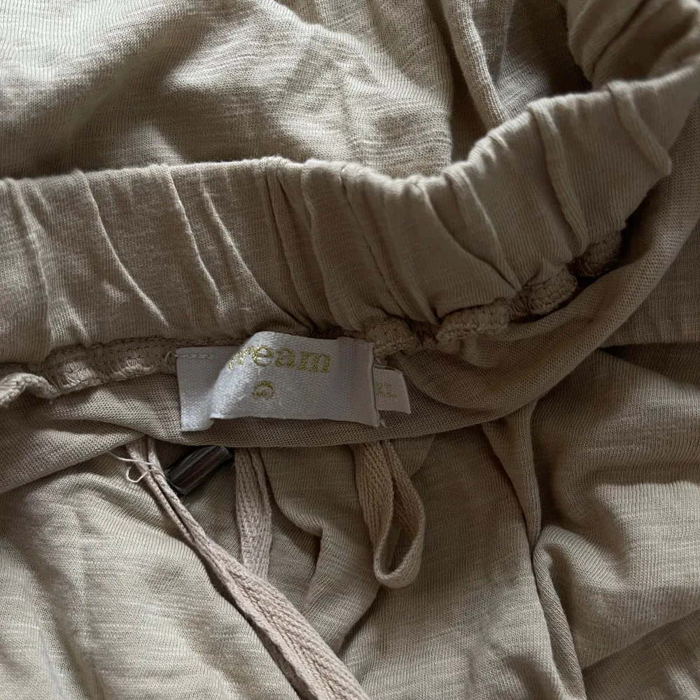 Beige kjol i bomull, kan användas som vanlig eller strand kjol. Kan dra åt i midjan . Hameet.