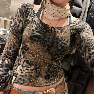 Leopard Mönstrad festtopp med vida ärmar - Säljer en sjukt snygg festtopp med leopard- och paisleymönste!! Toppen har vida trekvartsärmar och en knytning framtill. Aldrig använd så i nyskick! passar xs-s
