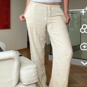 Beige linnebyxor med resårmidja - Snygga och bekväma beige linnebyxor med resårmidja. Perfekta för en avslappnad stil. Byxorna har en loose passform och är tillverkade i ett lätt och luftigt material.