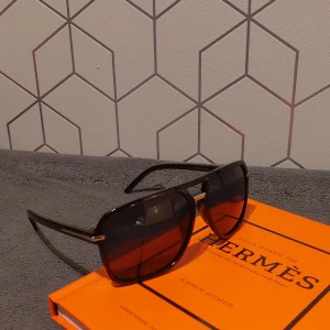 Svarta solglasögon med blått glas - Snygga svarta solglasögon med silverdetaljer och blått glas. Helt nya