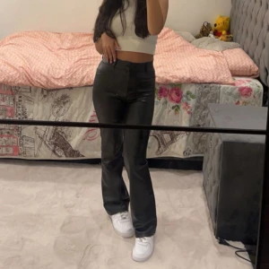 Svarta skinnbyxor - Snygga svarta skinnbyxor med en tight passform och låg midja. Perfekta för en trendig look. De har en klassisk design med raka ben och passar bra till både sneakers och klackar. De är dessutom vadderade vilket gör de perfekta till att ha på vintern!