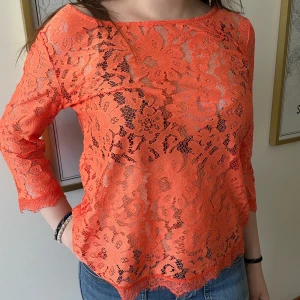 Orange spetsblus - Säljer en snygg orange spetsblus med trekvartsärm. Blusen har ett vackert blommigt mönster. Jätte bra skick och har används max 1 gång! Skriv vid intresse eller frågor❣️