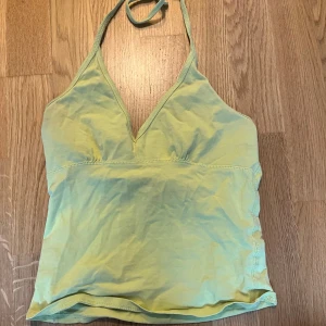 Ljusgul halterneck-linnetopp - Säljer en snygg ljusgul halterneck-linnetopp med v-ringning. 