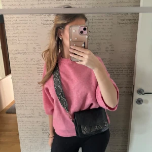 Svart axelväska med ormmönstrad rem - Snygg svart axelväska med en cool ormmönstrad rem. Perfekt för att ge din outfit en edgy touch. Väskan är kompakt och lätt att bära med sig överallt.