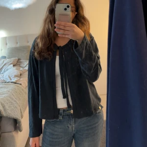 Mörkblå tröja från 157 - Säljer en mörkblå tröja från 157 i storlek S. Tröjan har långa ärmar och en knytning framtill som ger en fin detalj. 